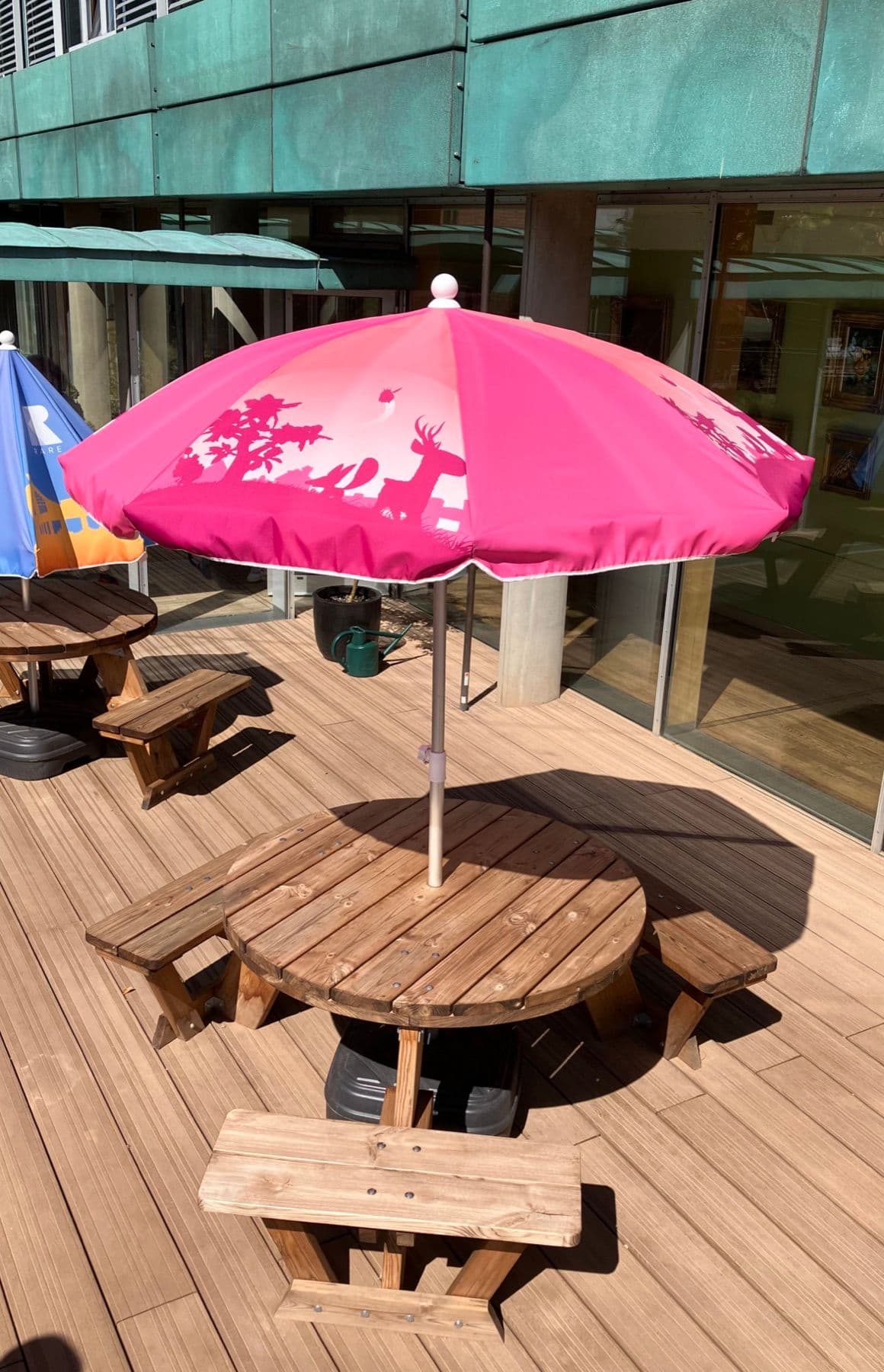 Pink branded parasol over outdoor seating